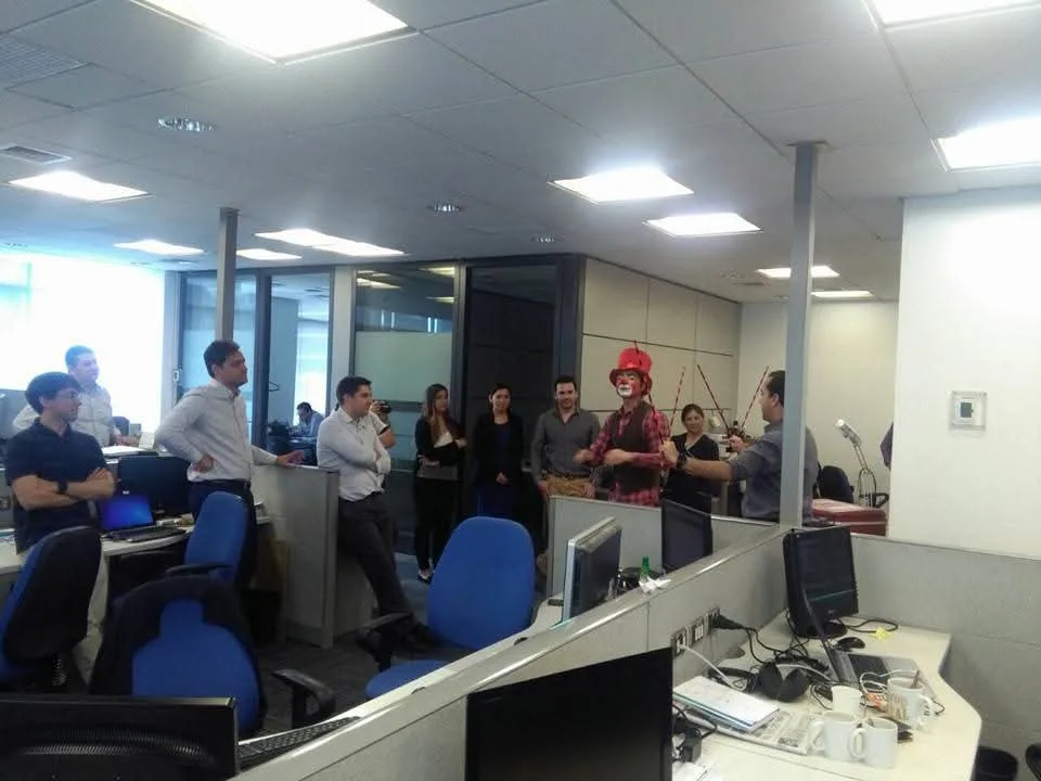 Equipo reunido entre puestos de oficina durante una dinámica facilitada